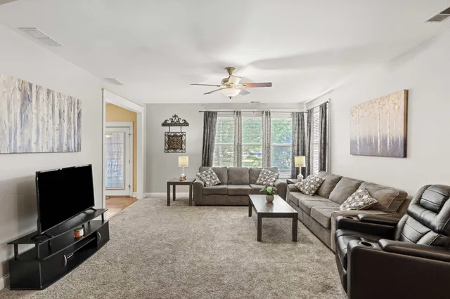 a living room with furniture a fireplace and a flat screen tv