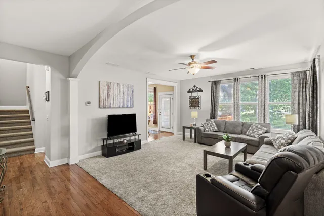a living room with furniture a flat screen tv and a large window
