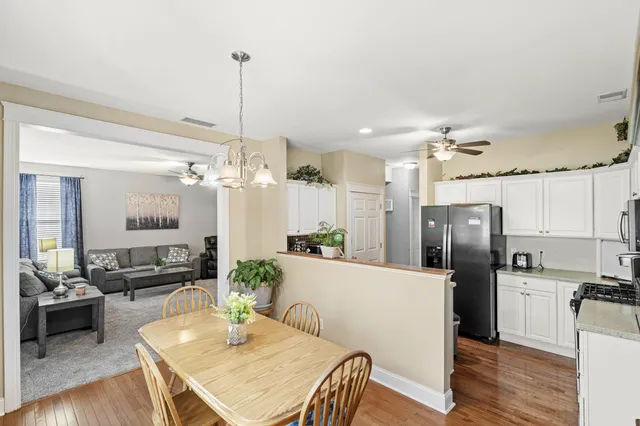 a kitchen with refrigerator cabinets dining table and chairs