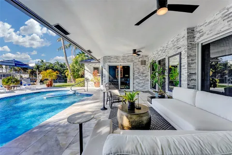 a large kitchen with stainless steel appliances granite countertop a stove top oven a sink dishwasher and white cabinets with wooden floor