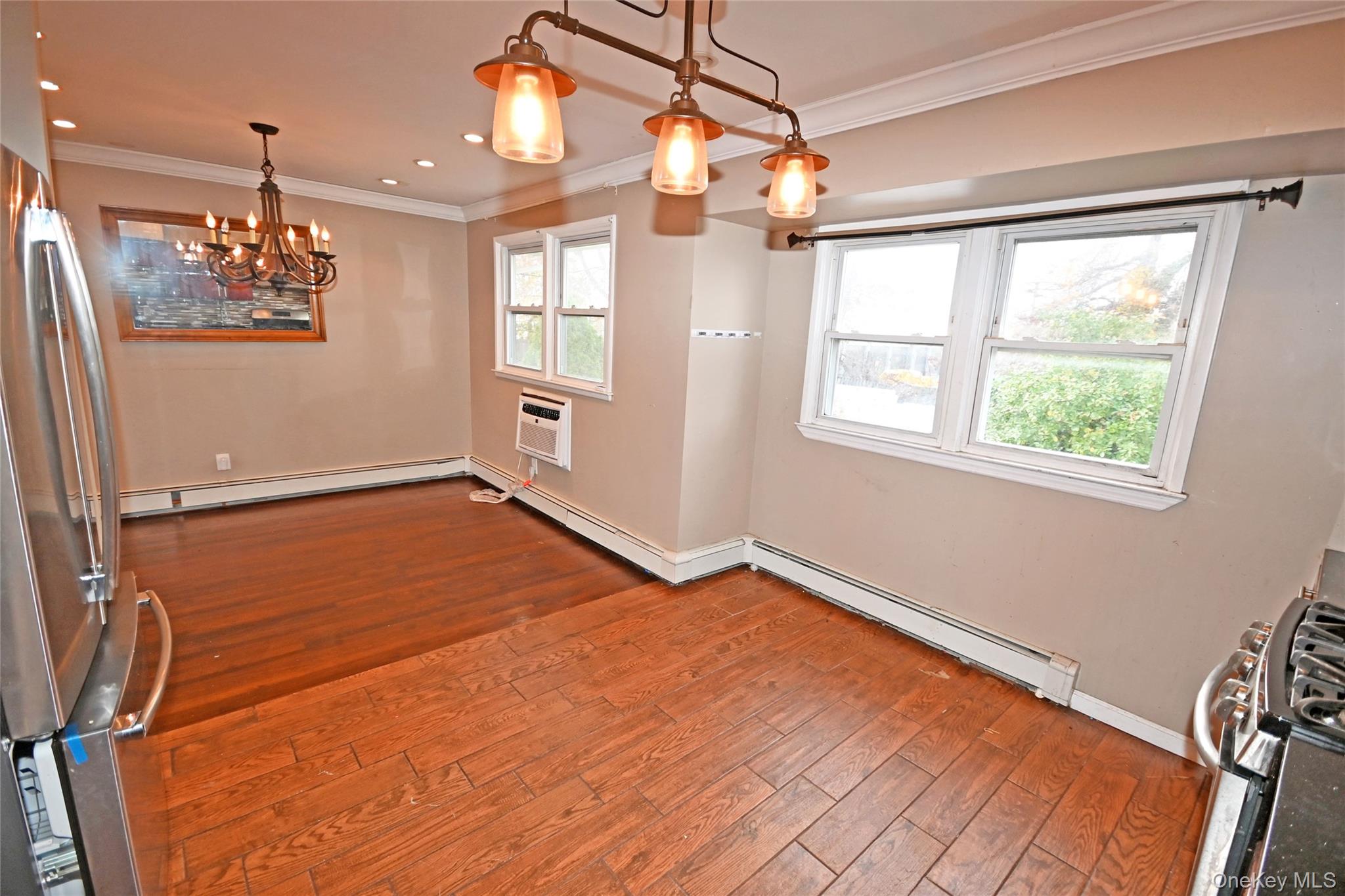 89 Osborne Road West Hempstead, NY 11552 - Photo 38 of 50 Unfurnished dining area featuring a chandelier, crown molding, hardwood / wood-style floors, baseboard heating, and recessed lighting