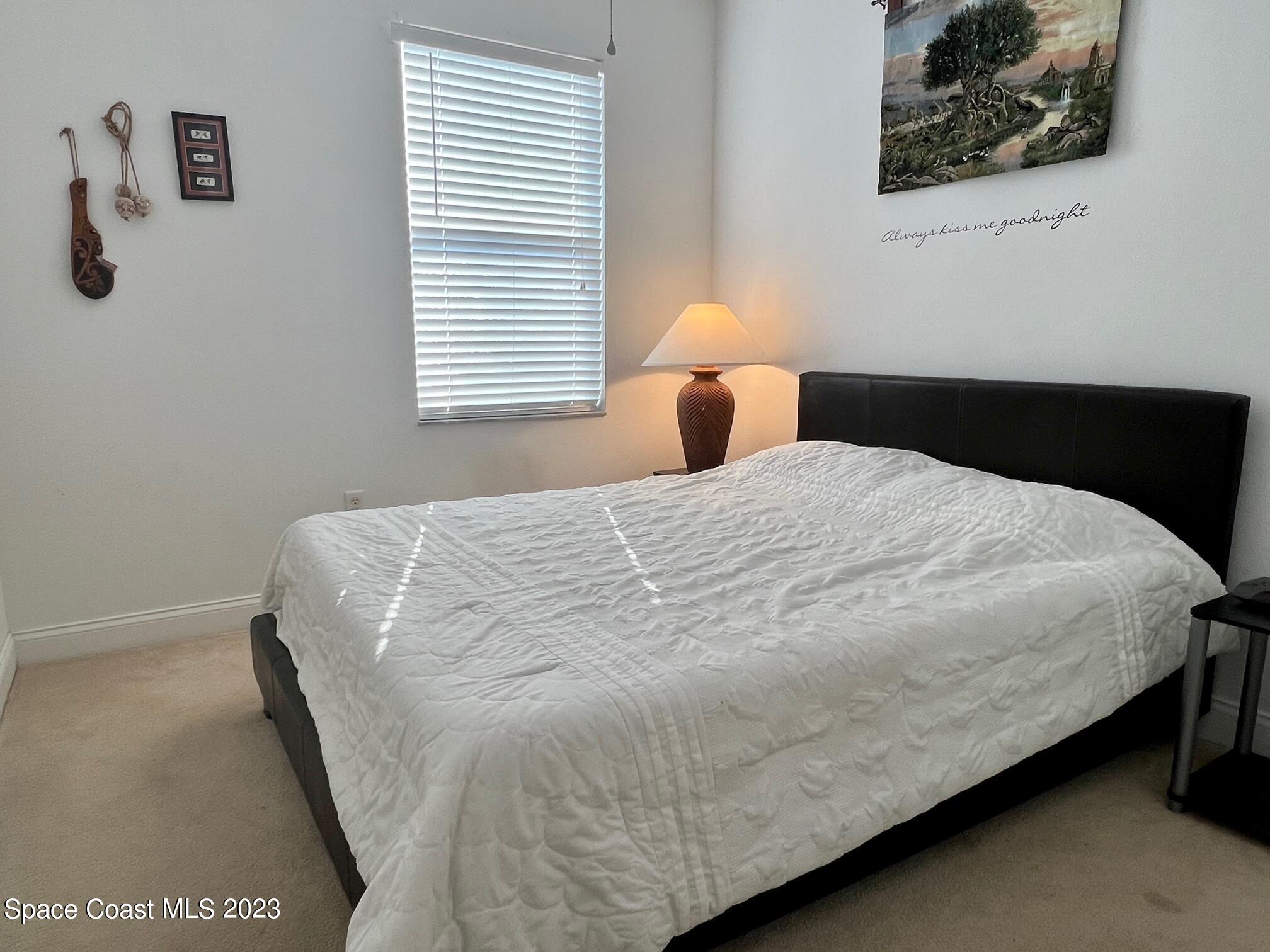 3193 Ricks Way Melbourne Beach, FL 32951 - Photo 11 of 22 a large bed sitting in a bedroom next to a window