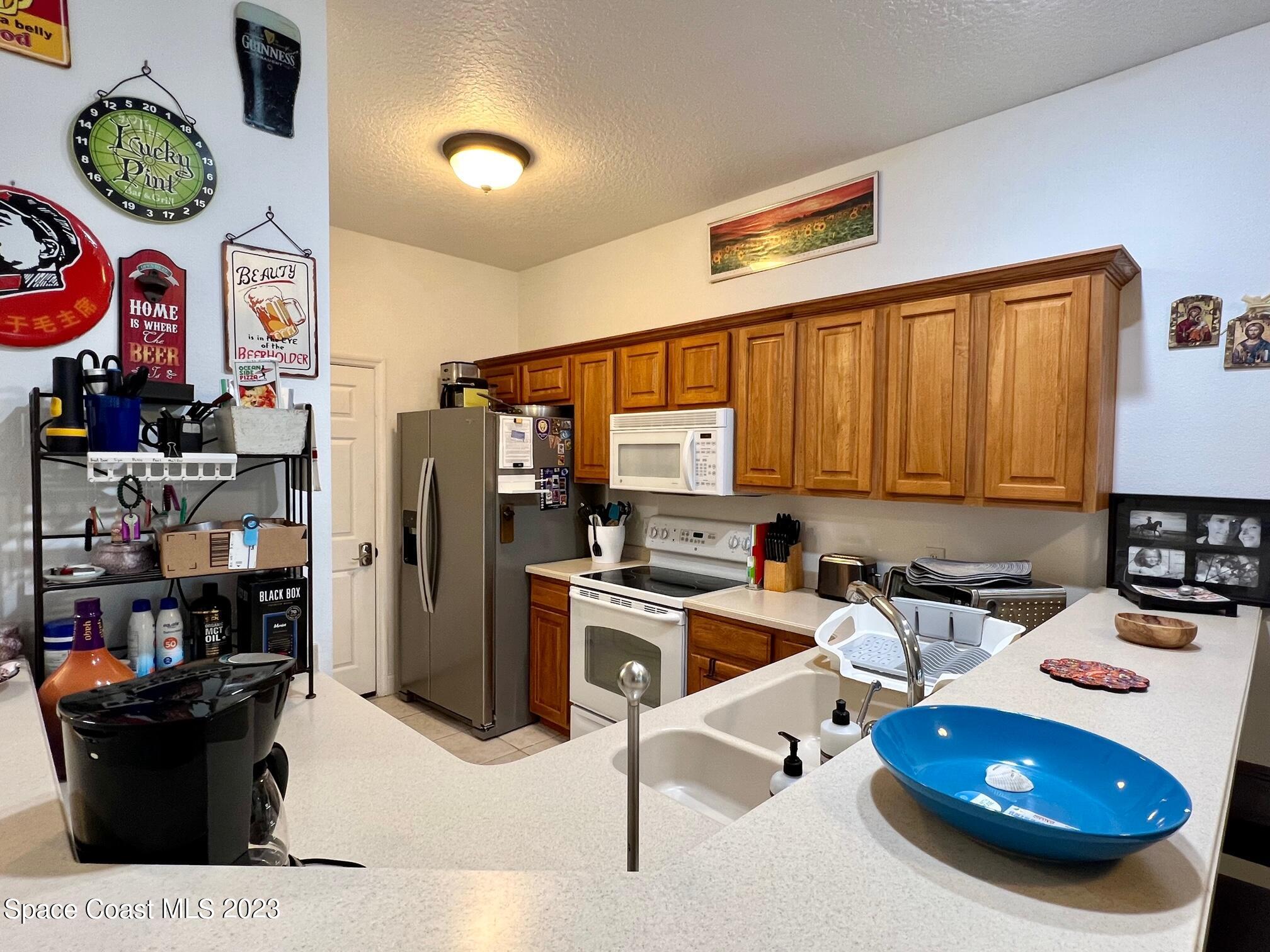 3193 Ricks Way Melbourne Beach, FL 32951 - Photo 6 of 22 a kitchen with a refrigerator and a stove top oven