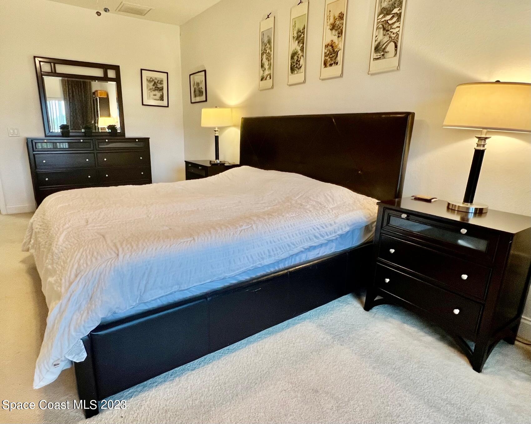 3193 Ricks Way Melbourne Beach, FL 32951 - Photo 9 of 22 a bedroom with a bed and a lamp on dresser