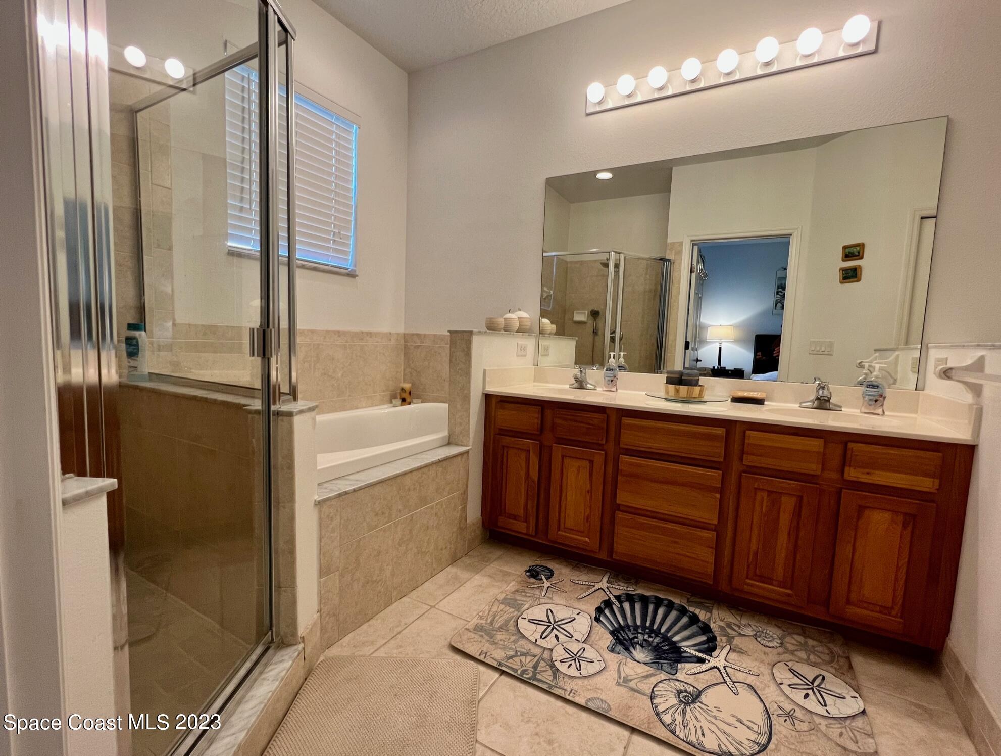 3193 Ricks Way Melbourne Beach, FL 32951 - Photo 10 of 22 a bathroom with a tub sink and mirror