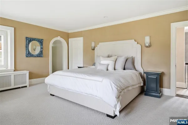 a bedroom with a bed and painting on the wall