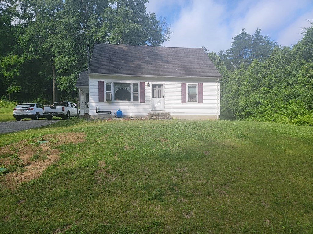 a front view of a house with a garden and trees