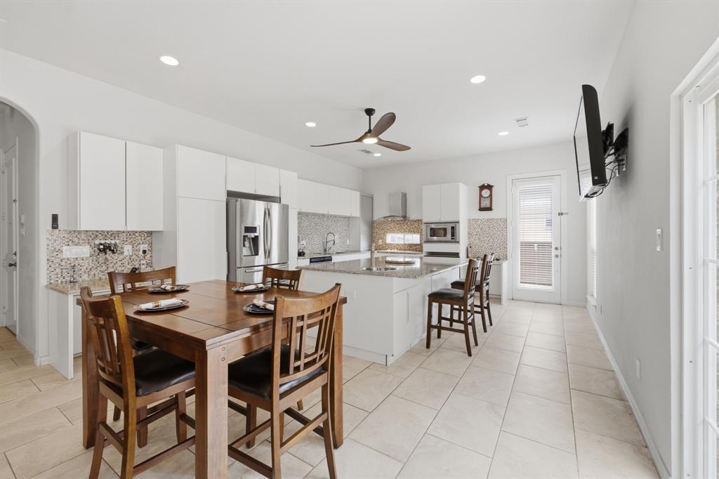 3315 Ricci Lane Irving, TX 75062 - Photo 14 of 40 Spacious kitchen featuring an expansive island with seating, a mosaic tile backsplash, recessed lighting, and large format floor tiles