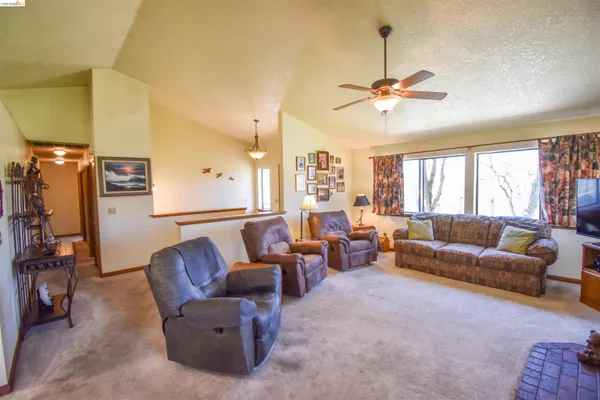 a living room with furniture a ceiling fan and a window