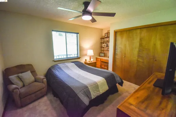 a bedroom with a bed couch and window