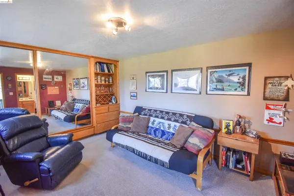 a living room with furniture a bookshelf and a window