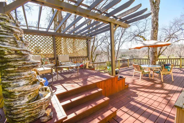 a view of a patio with lawn chairs floor to ceiling window with yard and outdoor seating
