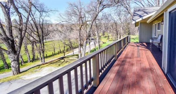a view of balcony with wooden floor and fence