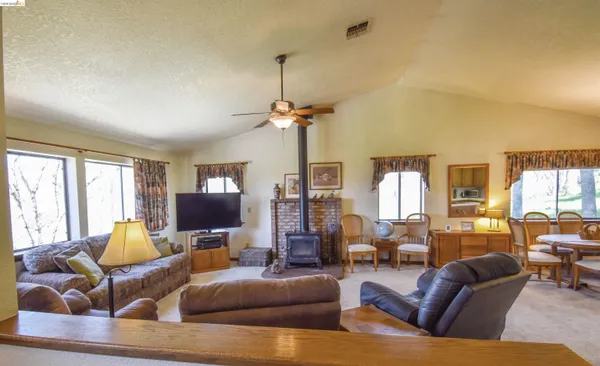 a living room with furniture ceiling fan and a window