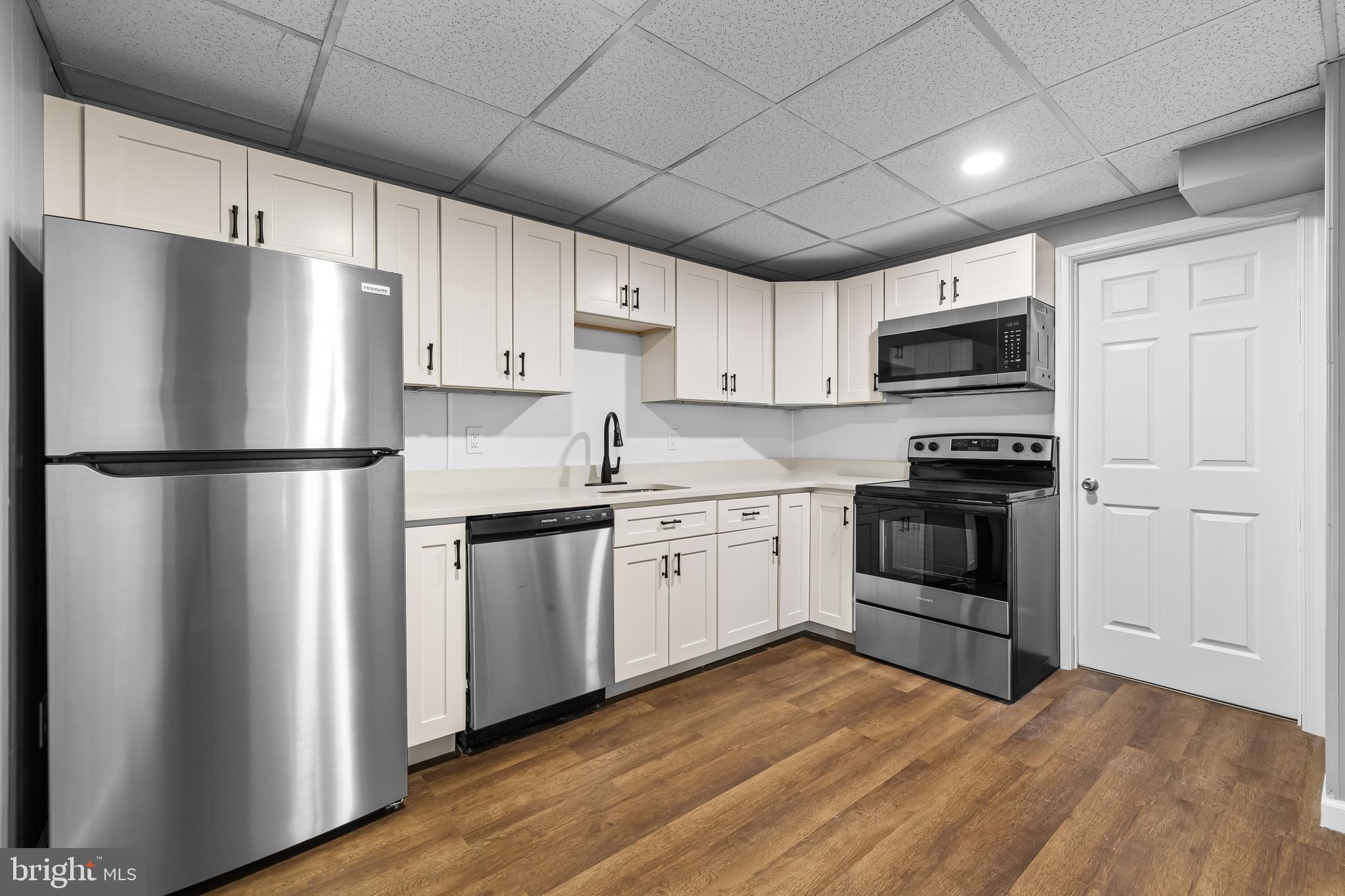 a kitchen with granite countertop a refrigerator stove and microwave