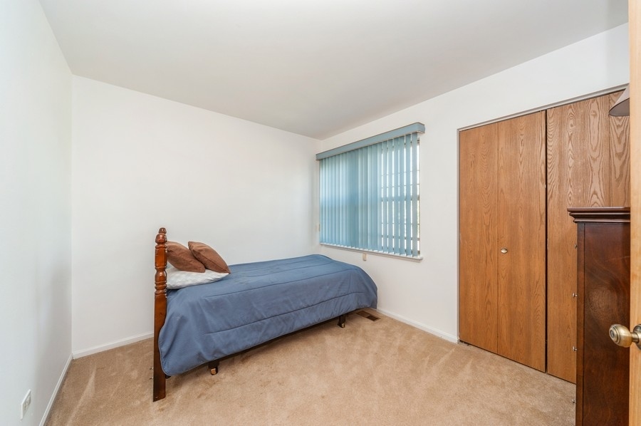968 Ridgefield Lane, Unit 968 Wheeling, IL 60090 - Photo 8 of 12 a bedroom with a bed and a window