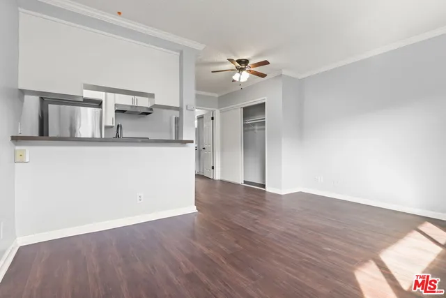 a view of a kitchen with wooden floor and ceiling fan