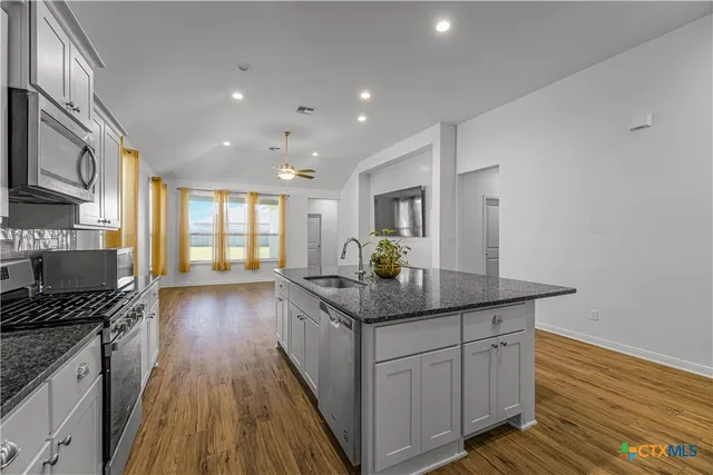 a kitchen with granite countertop counter space a sink appliances and cabinets