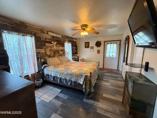 a spacious bedroom with a bed a dresser and mirror