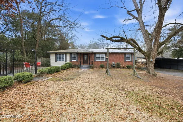 a front view of a house with a yard and potted plants