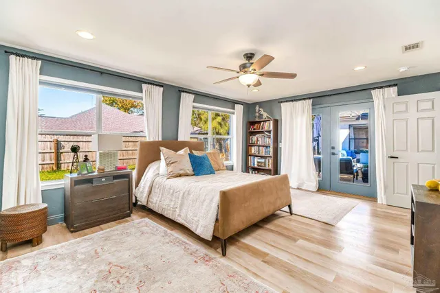a spacious bedroom with a large bed and a chandelier