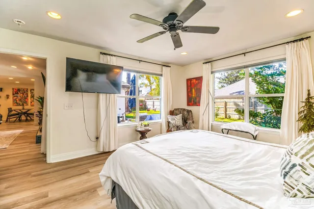 a bedroom with a bed and a large window with the outer view