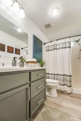 a bathroom with a double vanity sink toilet and a mirror