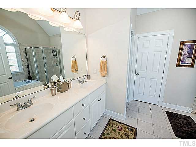 208 Okamato Street Raleigh, NC 27603 - Photo 13 of 25 Vaulted master bathroom with dual sink marble vanity, tile and walk-in closet.