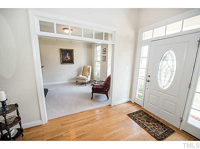 208 Okamato Street Raleigh, NC 27603 - Photo 2 of 25 Foyer with hardwoods and transom windows above doorways. A view looking into the formal living room.
