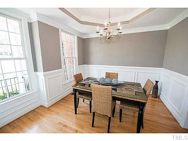 208 Okamato Street Raleigh, NC 27603 - Photo 4 of 25 Formal dining room with tray ceiling, hardwoods, wainscoting, crown and chair rail moldings.