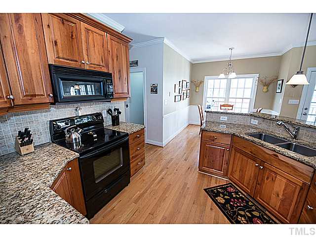 208 Okamato Street Raleigh, NC 27603 - Photo 10 of 25 Another angle of the kitchen looking out to the breakfast room. Breakfast room has beadboard, chair rail molding and to the right is a French door to the screened porch.