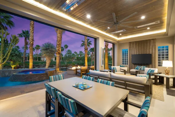 a living room with furniture a flat screen tv and a floor to ceiling window