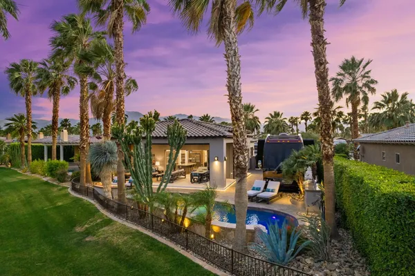 a view of a house with backyard and sitting area