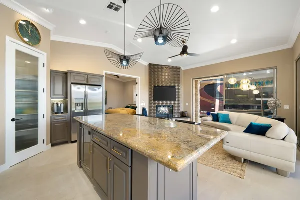 a kitchen with stainless steel appliances granite countertop a stove refrigerator and a view of living room