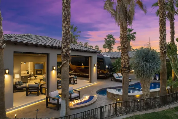 a view of a house with backyard water fountain and sitting area