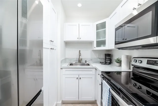 a kitchen with stainless steel appliances a sink stove and cabinets