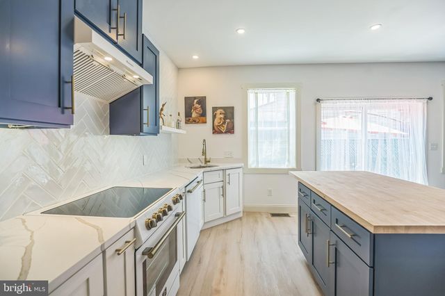 a kitchen that has a sink a stove and a wooden floor
