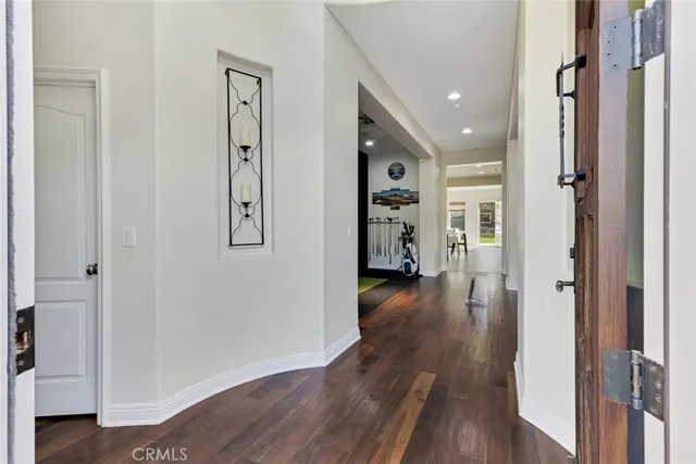 a view of a hallway with wooden floor closet and livingroom view