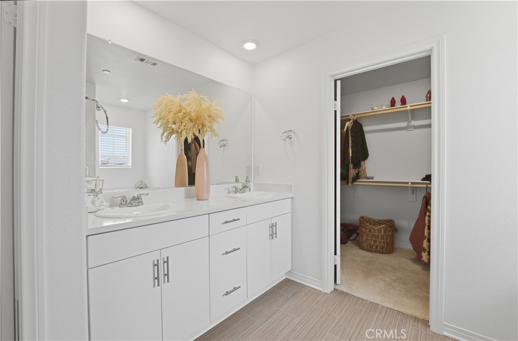 2522 Gunner Ridge Way Rialto, CA 92377 - Photo 19 of 28 a en suite bathroom with a double vanity sink and a mirror