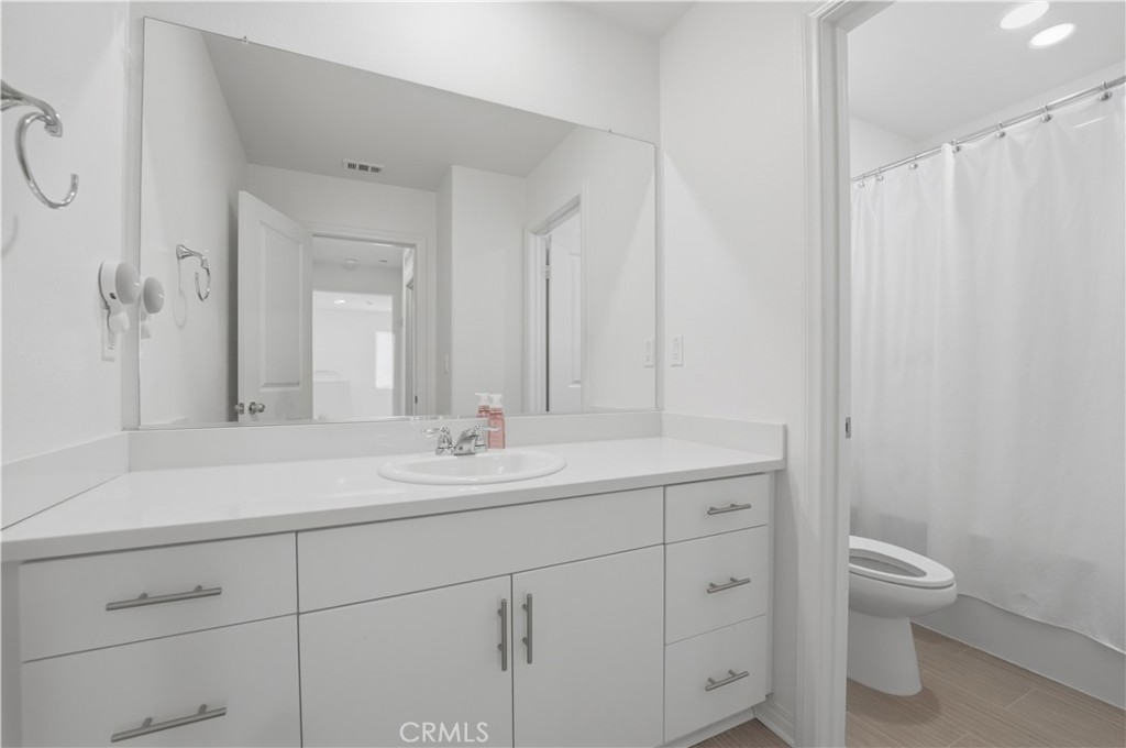 2522 Gunner Ridge Way Rialto, CA 92377 - Photo 23 of 28 a bathroom with a toilet sink and mirror