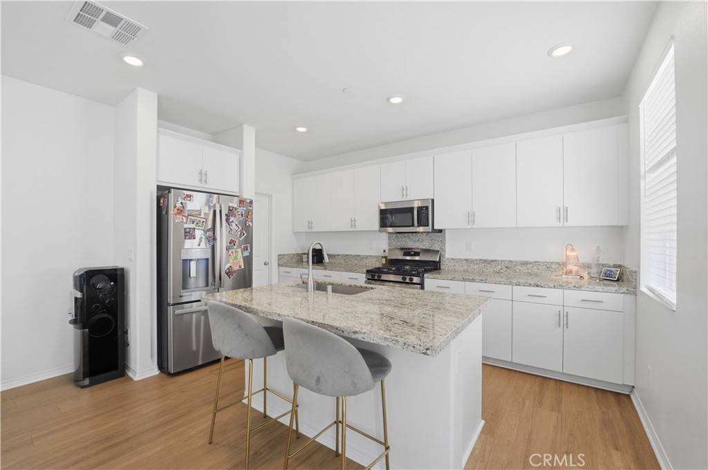 2522 Gunner Ridge Way Rialto, CA 92377 - Photo 10 of 28 a kitchen with stainless steel appliances granite countertop a sink a stove a refrigerator and cabinets