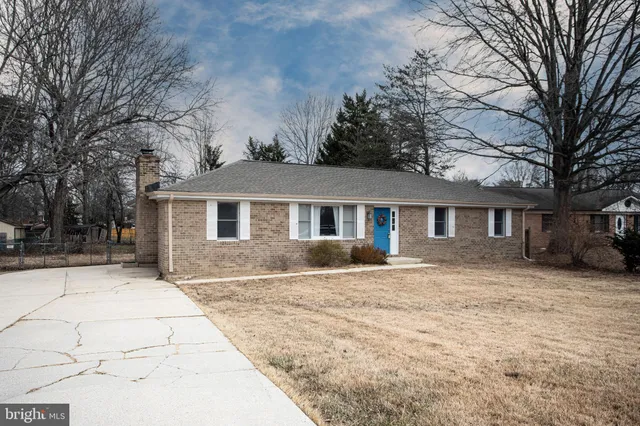 a front view of a house with a yard covered in snow
