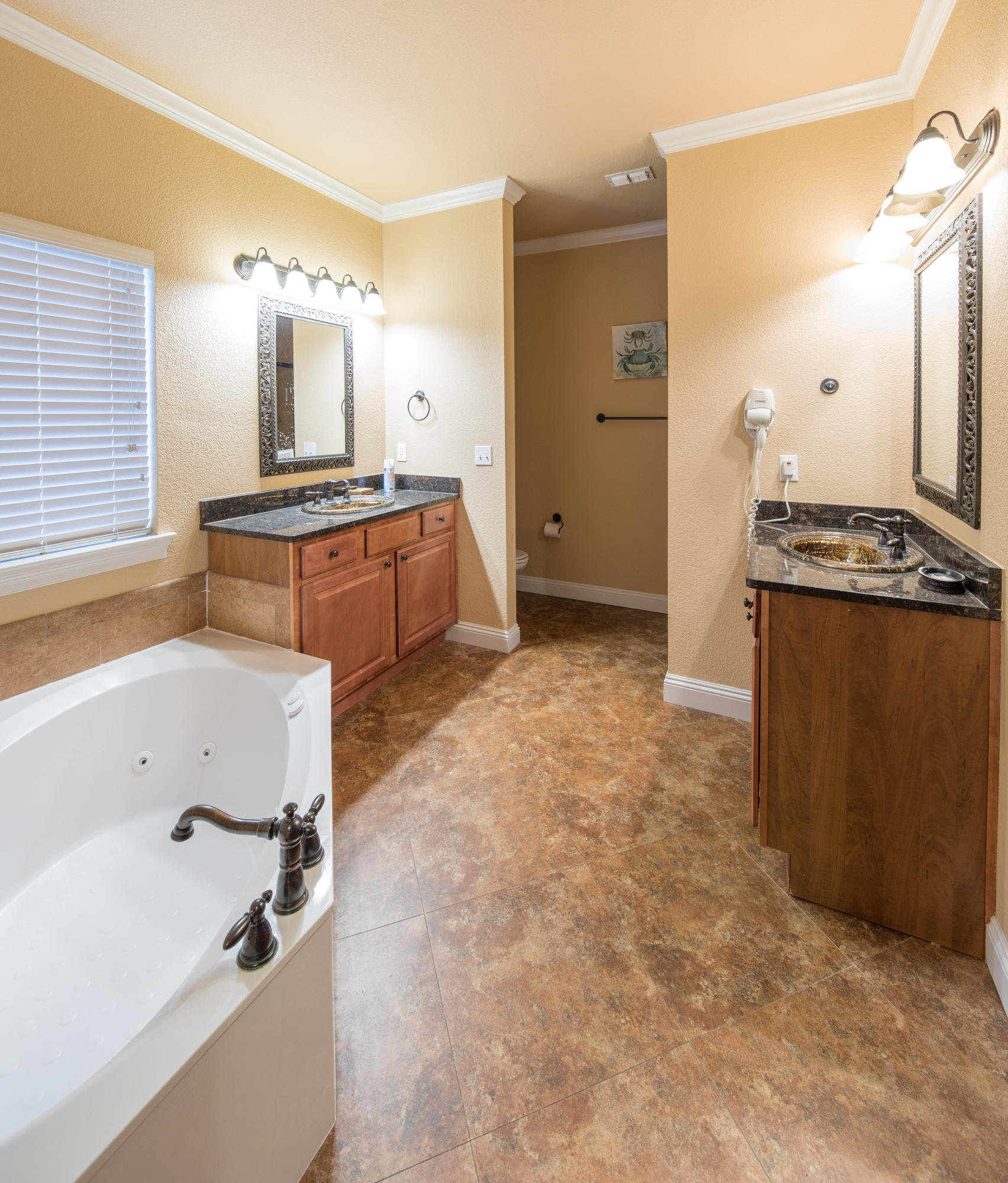 4554 Biscayne Way Destin, FL 32541 - Photo 14 of 24 a bathroom with a tub sink and mirror