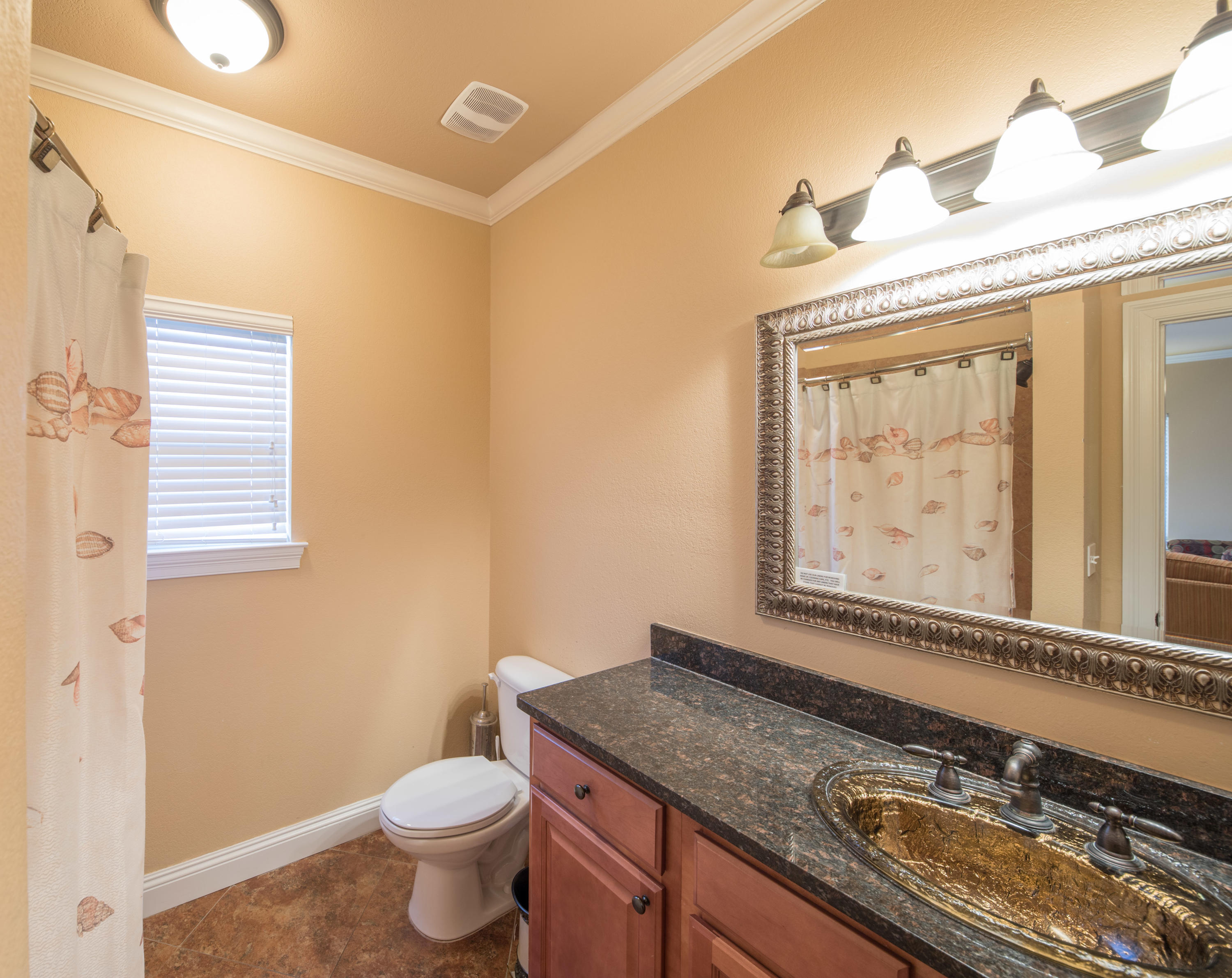 4554 Biscayne Way Destin, FL 32541 - Photo 22 of 24 a bathroom with a granite countertop sink a toilet and a mirror
