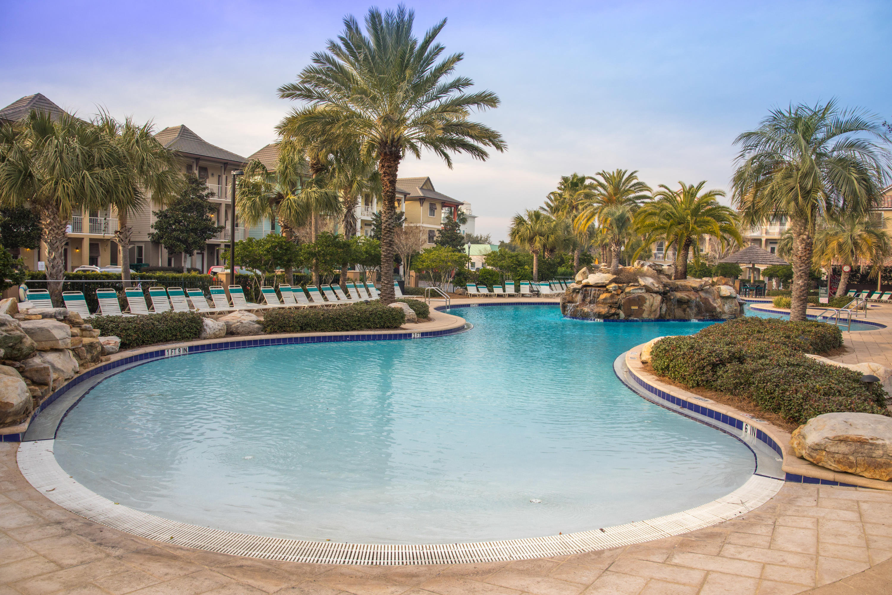 4554 Biscayne Way Destin, FL 32541 - Photo 5 of 24 a view of a swimming pool with a lawn chairs and palm tree