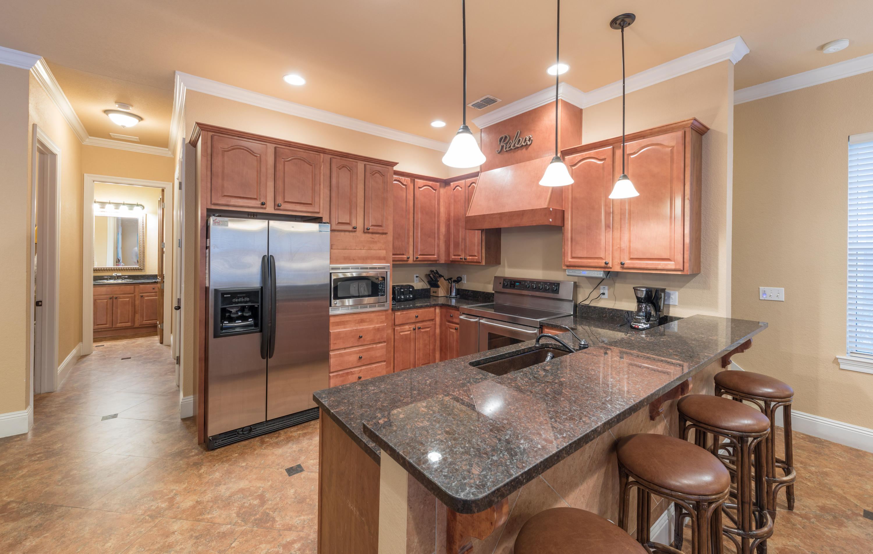 4554 Biscayne Way Destin, FL 32541 - Photo 9 of 24 a kitchen with stainless steel appliances granite countertop a sink a stove a refrigerator cabinets and chairs