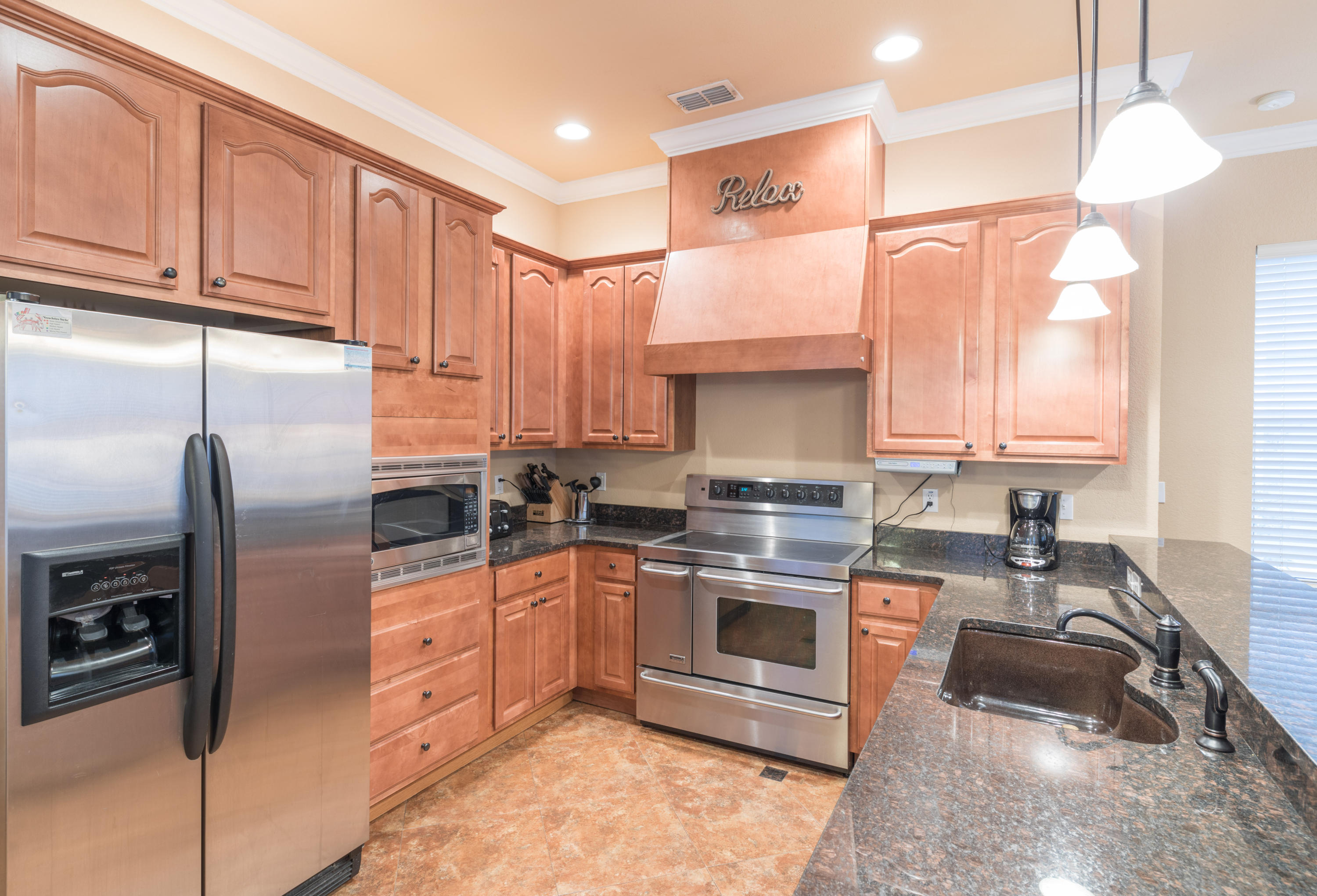 4554 Biscayne Way Destin, FL 32541 - Photo 10 of 24 a kitchen with stainless steel appliances granite countertop a stove a sink and a refrigerator