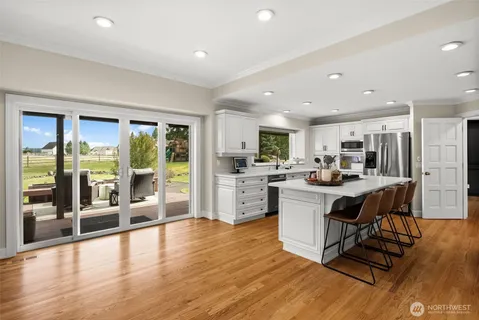 a kitchen with a sink appliances and wooden floor