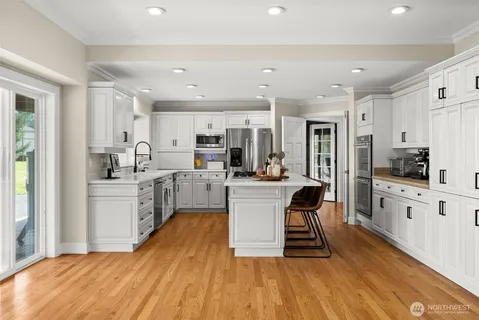 a kitchen with white cabinets and stainless steel appliances
