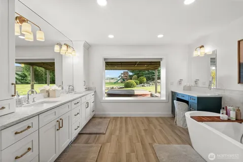 a bathroom with a granite countertop sink a large mirror and a bathtub